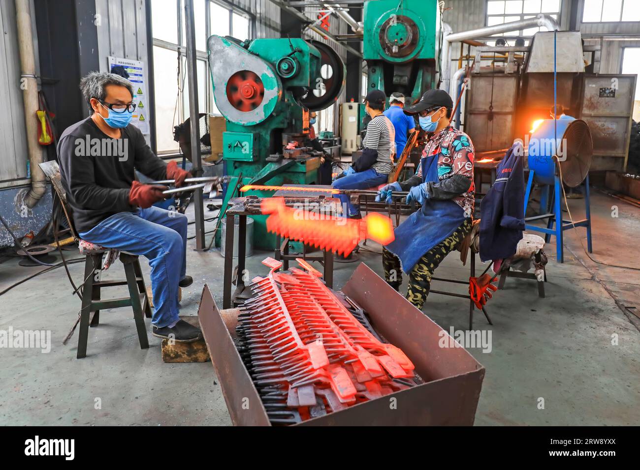 CONTEA DI LUANNAN, Cina - 24 settembre 2021: I lavoratori lavorano intensamente su una linea di produzione di forgiatura in uno stabilimento di produzione di utensili hardware nel nord della Cina Foto Stock