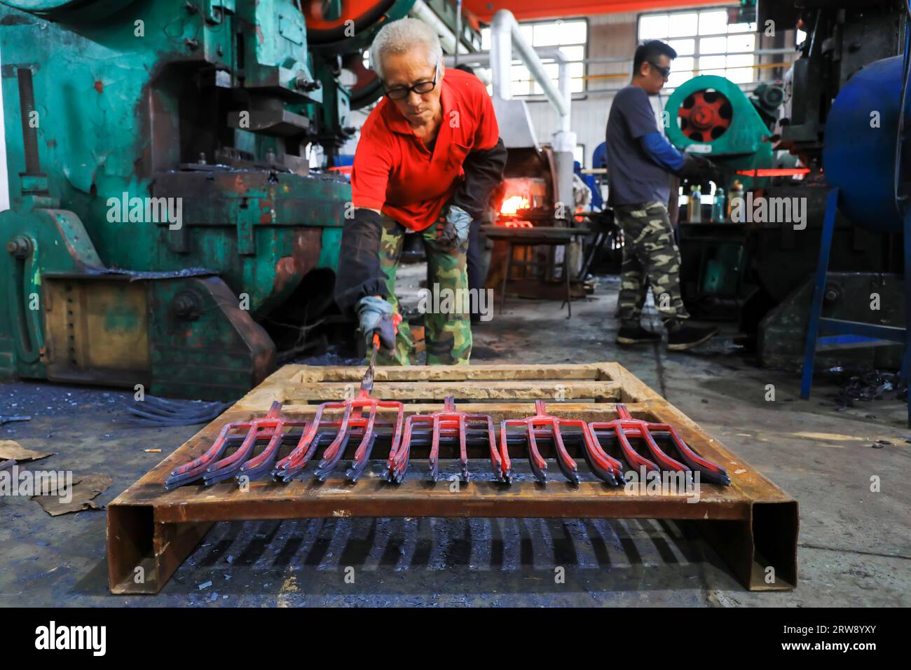 CONTEA DI LUANNAN, Cina - 24 settembre 2021: I lavoratori lavorano intensamente su una linea di produzione di forgiatura in uno stabilimento di produzione di utensili hardware nel nord della Cina Foto Stock