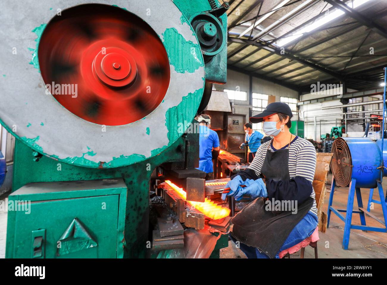 CONTEA DI LUANNAN, Cina - 24 settembre 2021: I lavoratori lavorano intensamente su una linea di produzione di forgiatura in uno stabilimento di produzione di utensili hardware nel nord della Cina Foto Stock