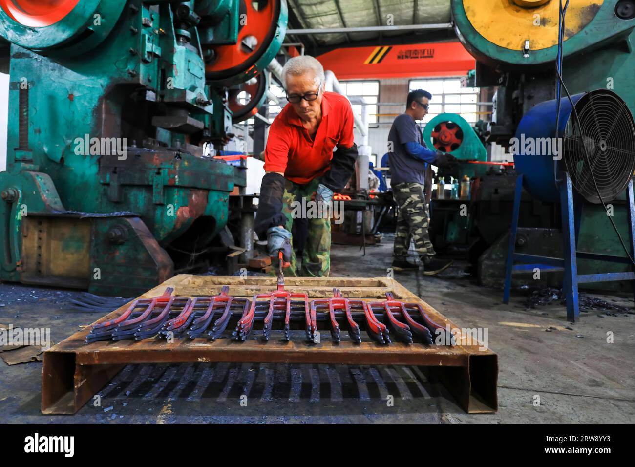 CONTEA DI LUANNAN, Cina - 24 settembre 2021: I lavoratori lavorano intensamente su una linea di produzione di forgiatura in uno stabilimento di produzione di utensili hardware nel nord della Cina Foto Stock