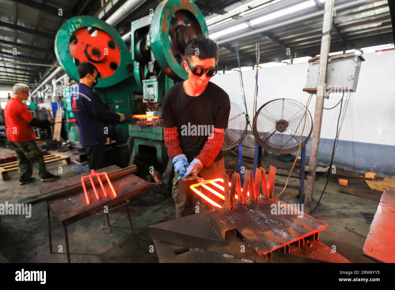 CONTEA DI LUANNAN, Cina - 24 settembre 2021: I lavoratori lavorano intensamente su una linea di produzione di forgiatura in uno stabilimento di produzione di utensili hardware nel nord della Cina Foto Stock