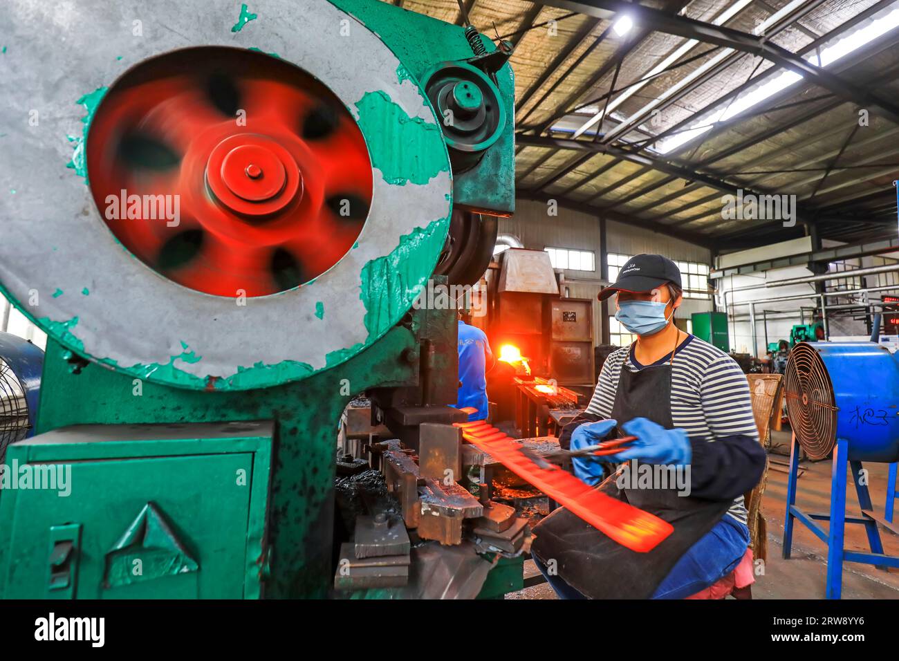 CONTEA DI LUANNAN, Cina - 24 settembre 2021: I lavoratori lavorano intensamente su una linea di produzione di forgiatura in uno stabilimento di produzione di utensili hardware nel nord della Cina Foto Stock