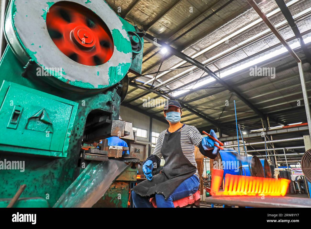CONTEA DI LUANNAN, Cina - 24 settembre 2021: I lavoratori lavorano intensamente su una linea di produzione di forgiatura in uno stabilimento di produzione di utensili hardware nel nord della Cina Foto Stock