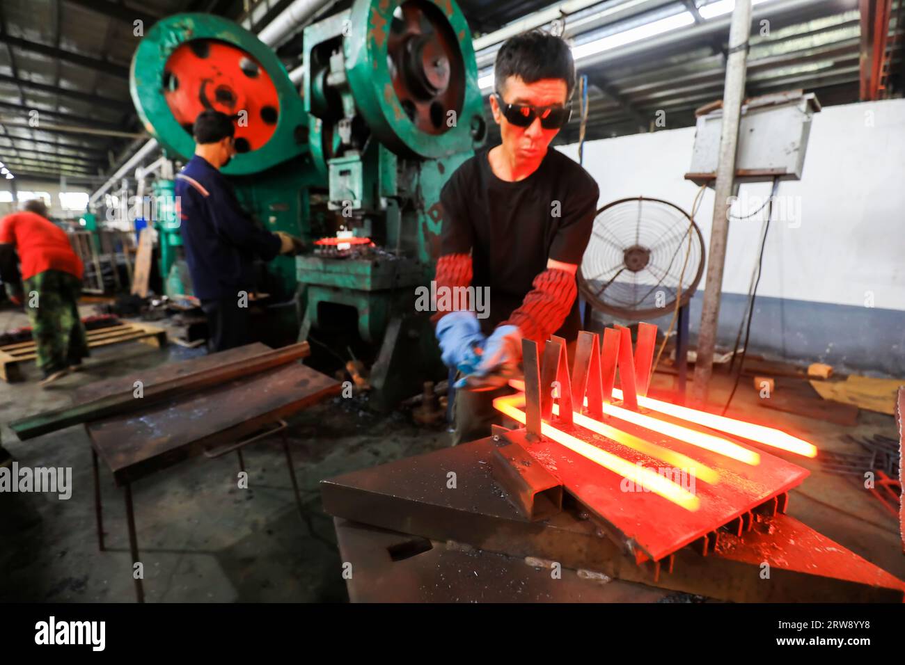 CONTEA DI LUANNAN, Cina - 24 settembre 2021: I lavoratori lavorano intensamente su una linea di produzione di forgiatura in uno stabilimento di produzione di utensili hardware nel nord della Cina Foto Stock
