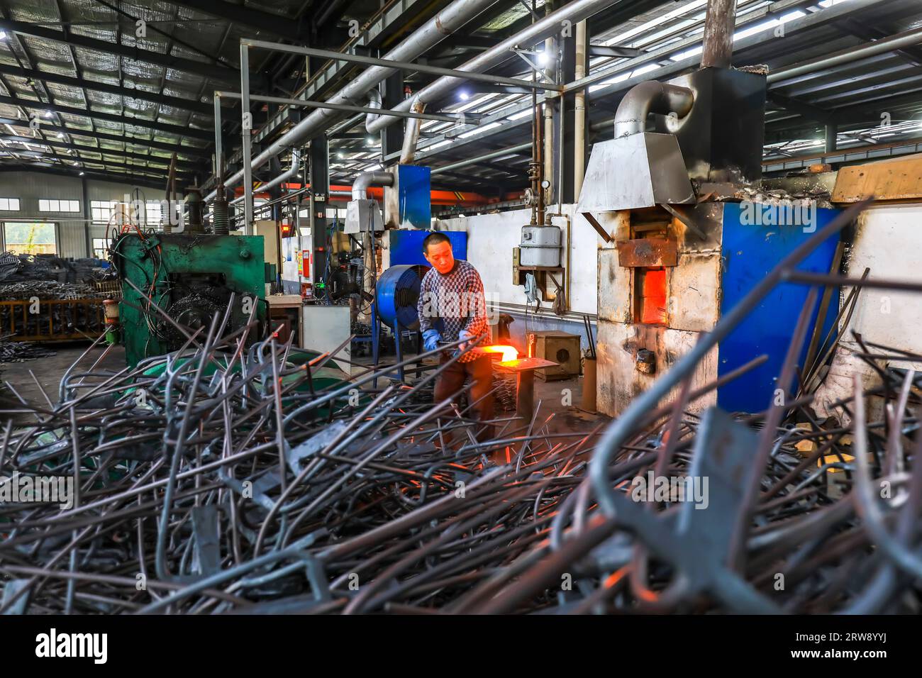 CONTEA DI LUANNAN, Cina - 24 settembre 2021: I lavoratori lavorano intensamente su una linea di produzione di forgiatura in uno stabilimento di produzione di utensili hardware nel nord della Cina Foto Stock