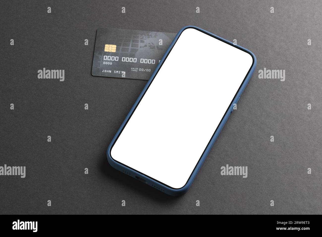 Smartphone con schermo vuoto e carta di credito su sfondo nero Foto Stock