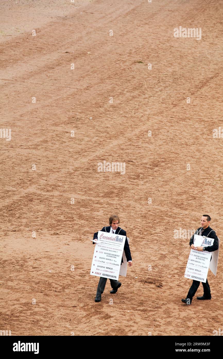 Mark Jenkins e il direttore generale dell'hotel Cavendish James Ryder che indossa panini sulla spiaggia di Torre Abbey, girando la serie 4 dell'hotel Foto Stock