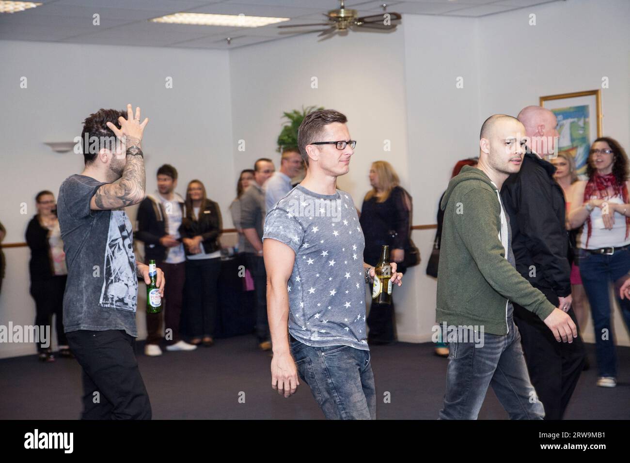 Ritchie Neville con una bottiglia di sidro che entra in una stanza con Sean Conlon e Scott Robinson per incontrare i fan dopo cinque spettacoli Foto Stock