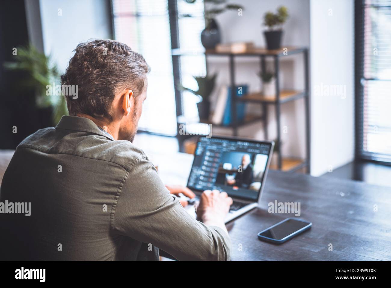 Lavoratore di mezza età dedicato in ufficio, programmatore esperto, profondamente impegnato nella scrittura di programmi. Realizza meticolosamente linee di codice, competenze e professionalità nell'ambito dello sviluppo software. Foto di alta qualità Foto Stock