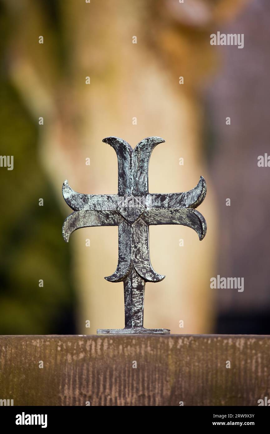 Piccolo e semplice croce di metallo su una lastra tombale, la profondità di campo di una composizione Foto Stock