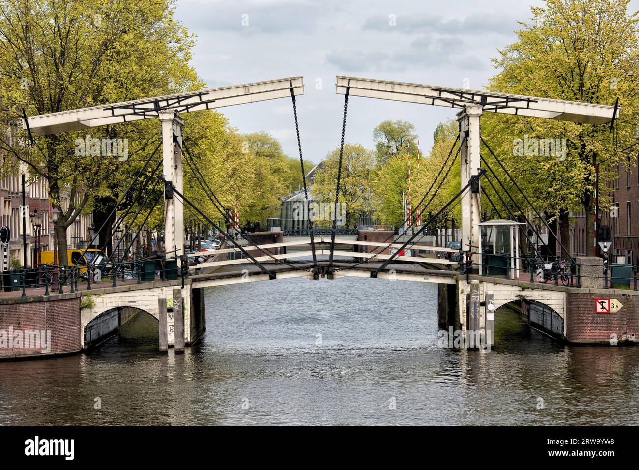 Ponte sulla foce del canale Nieuwe Herengracht ad Amsterdam, Paesi Bassi, sul primo piano del fiume Amstel Foto Stock