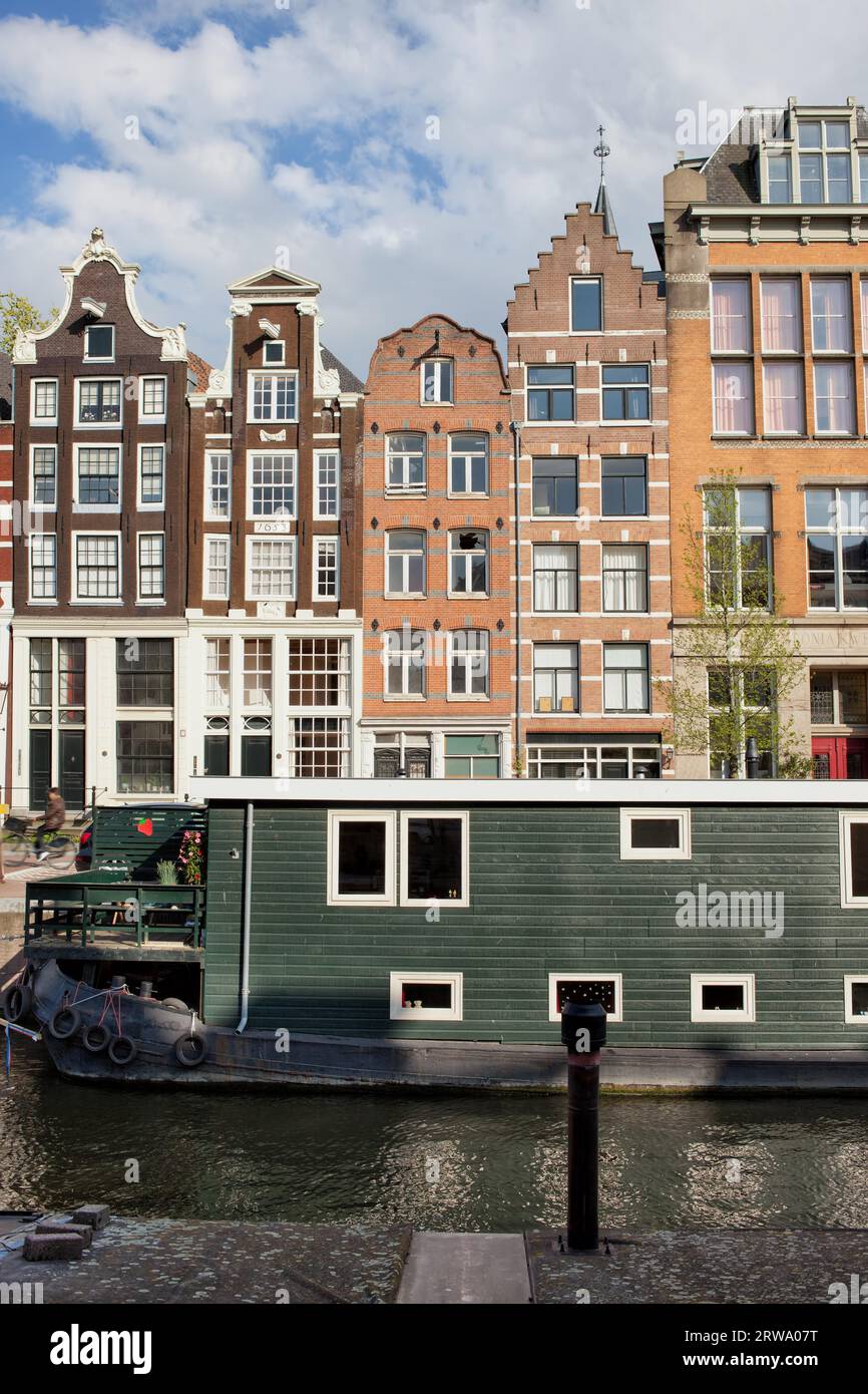 Case sui canali in stile olandese e chiatta residenziale su un canale ad Amsterdam, Olanda, Paesi Bassi Foto Stock