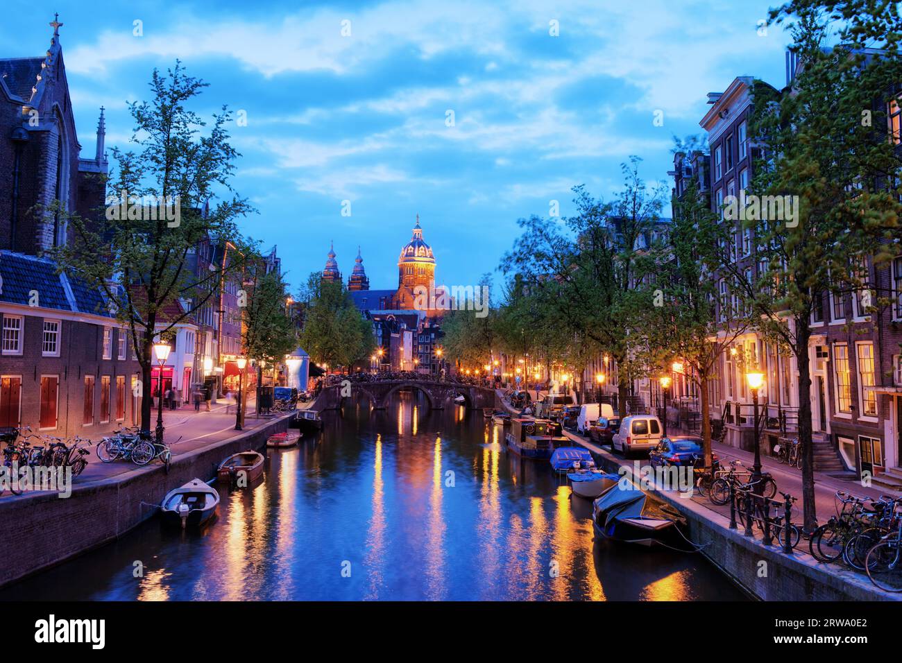 Serata nella città di Amsterdam in Olanda, Paesi Bassi, canale Oudezijds Voorburgwal, Chiesa di San Nicholas all'estremità Foto Stock