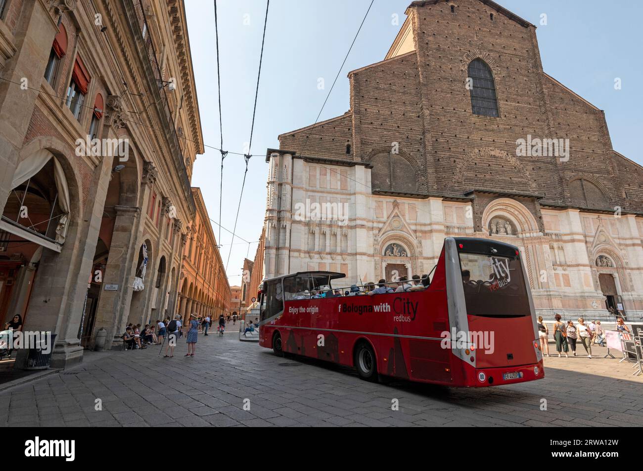 Uno degli autobus rossi della città che portano i turisti in un tour di Bologna con partenza da Piazza maggiore, punto di partenza e di arrivo di fronte a porta Magna Foto Stock