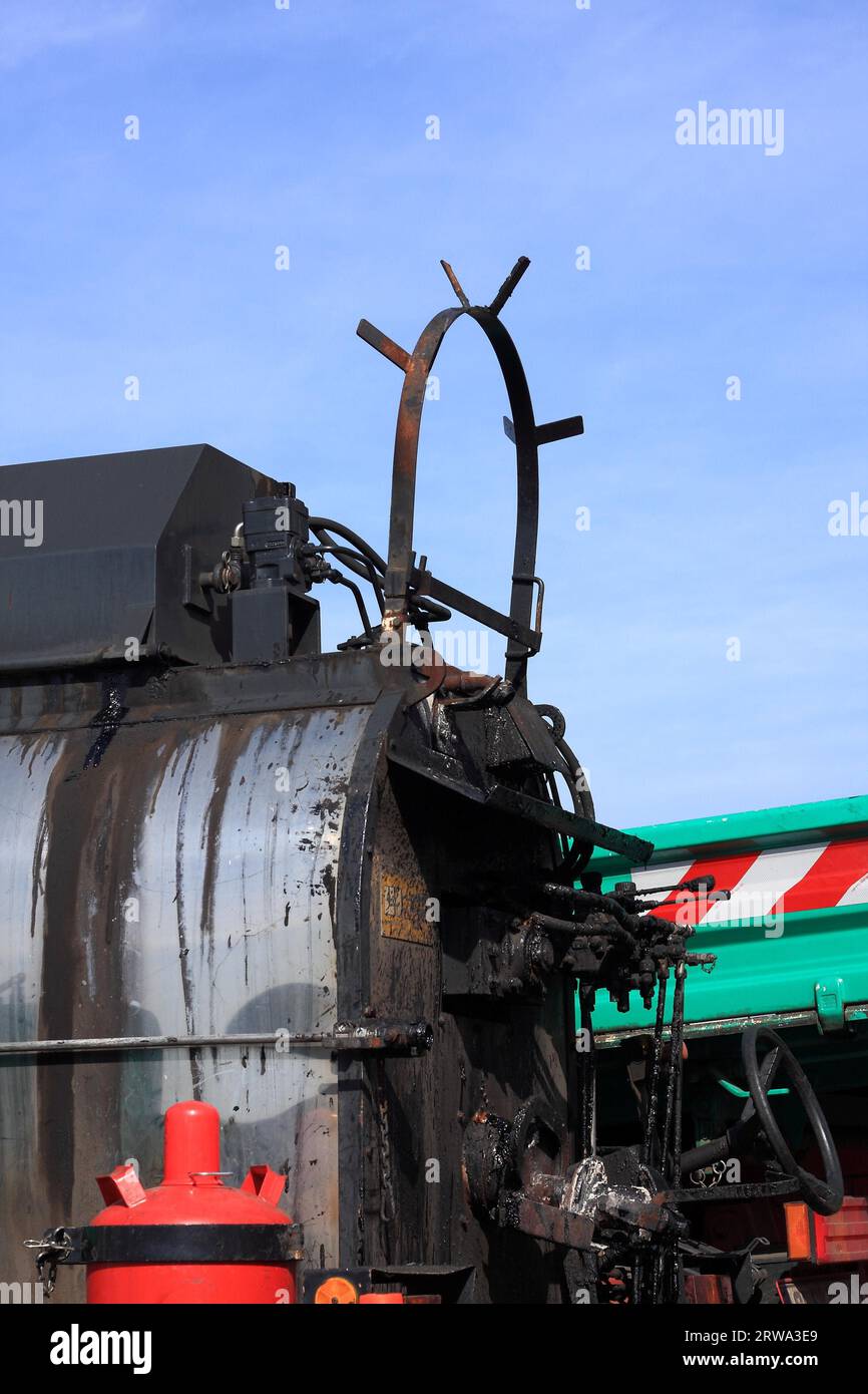 Lavori su un nuovo fondo stradale, un fornello per catrame, una bombola di gas e un camion, dettaglio, cielo blu di sfondo Foto Stock