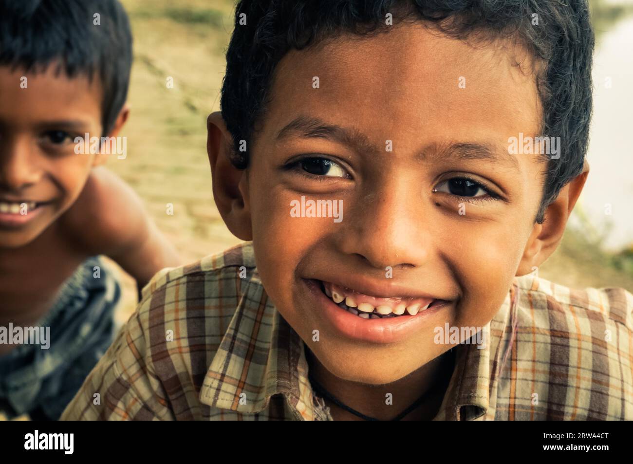 Chittagong, Bangladesh, circa luglio 2012: Giovani ragazzi sorridenti con i capelli castani e gli occhi marroni sorridono piacevolmente alla macchina fotografica nel villaggio rurale vicino Foto Stock