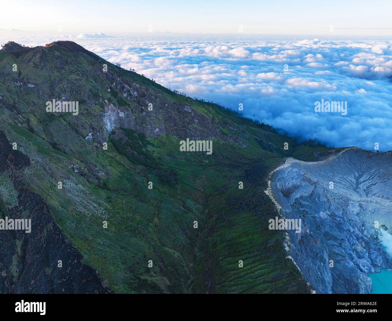 Vista aerea incredibile della scogliera rocciosa delle Montagne al vulcano Kawah Ijen con nebbia all'alba. Incredibile vista del paesaggio naturale a Giava Est, Indonesia. Naturale l Foto Stock