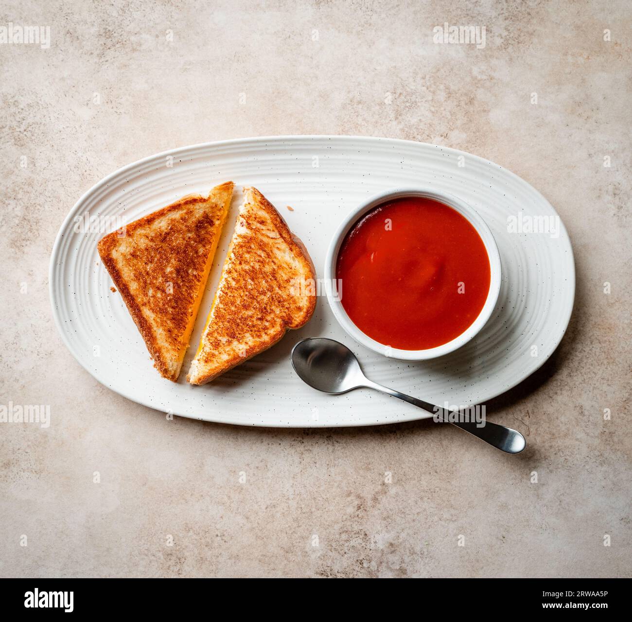 Vista dall'alto del sandwich al formaggio grigliato e della zuppa di pomodoro sul piatto. Foto Stock