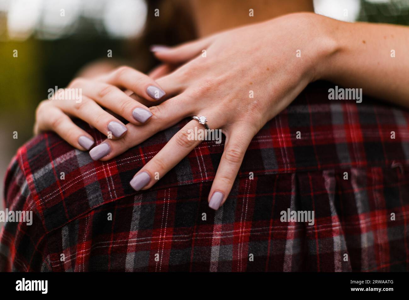 La mano di una donna che mostra il suo anello di fidanzamento con diamanti Foto Stock