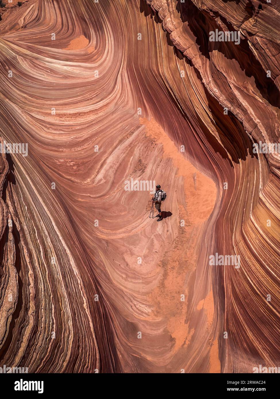 Un solitario escursionista maschile all'interno della famosa Wave a North Coyote Buttes Foto Stock