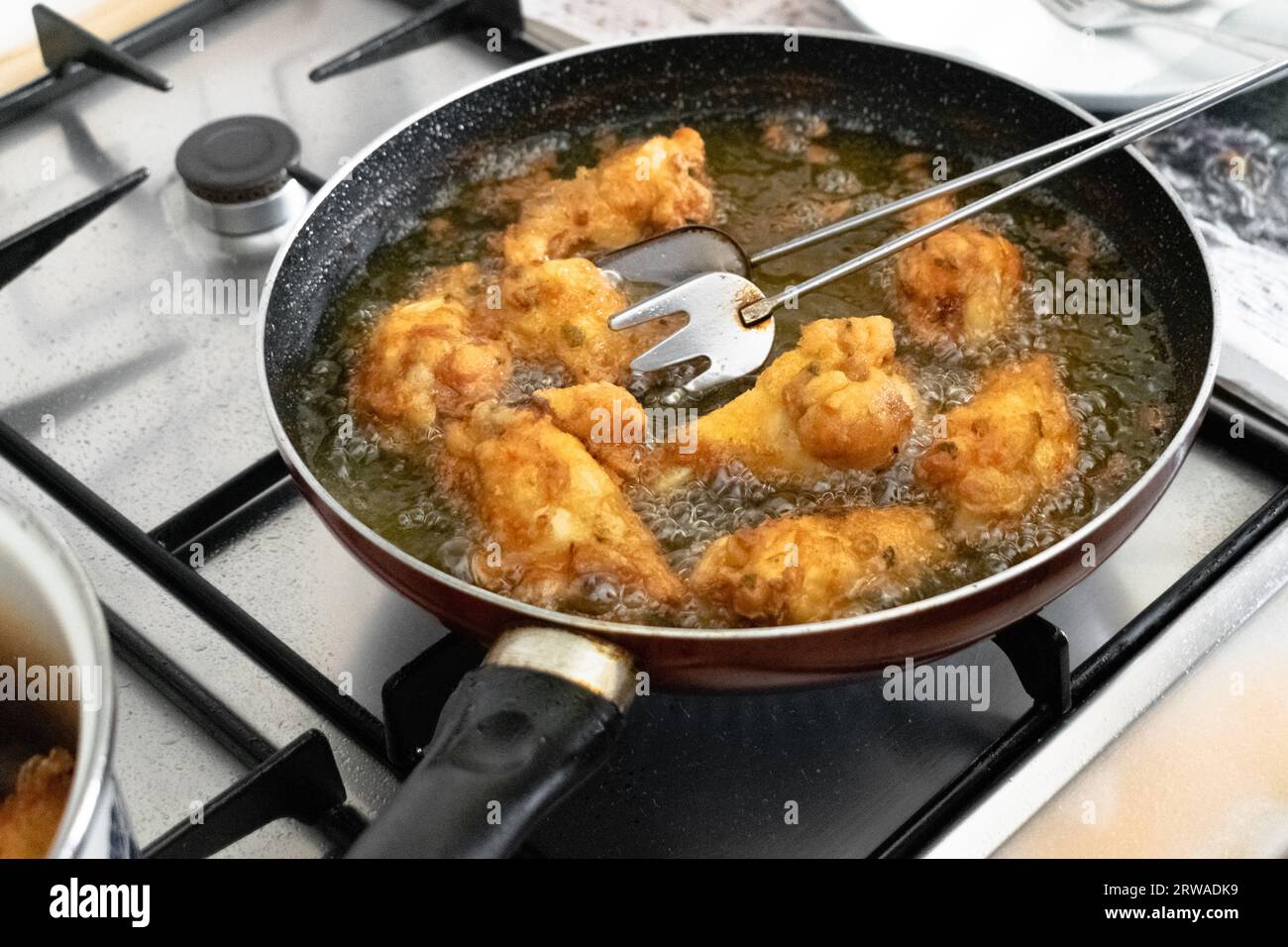 Friggere le ali di pollo in olio di palma vegetale caldo nella padella Foto Stock