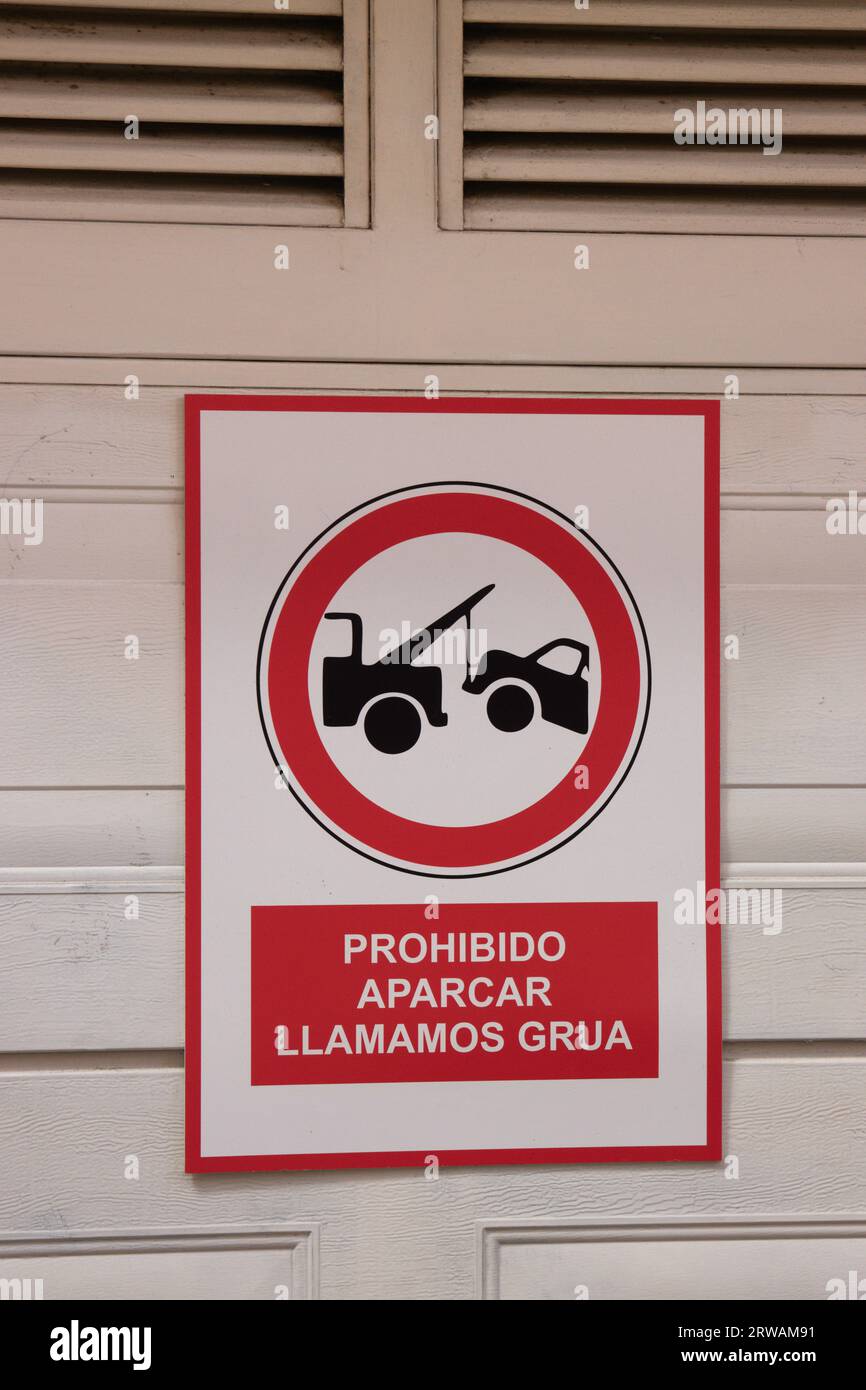 Primo piano di un cartello stradale che esclude il divieto di parcheggiare in spagnolo perché chiamano la gru Foto Stock Primo piano di un cartello stradale che esclude il divieto di parcheggiare in spagnolo perché chiamano la gru Foto Stock