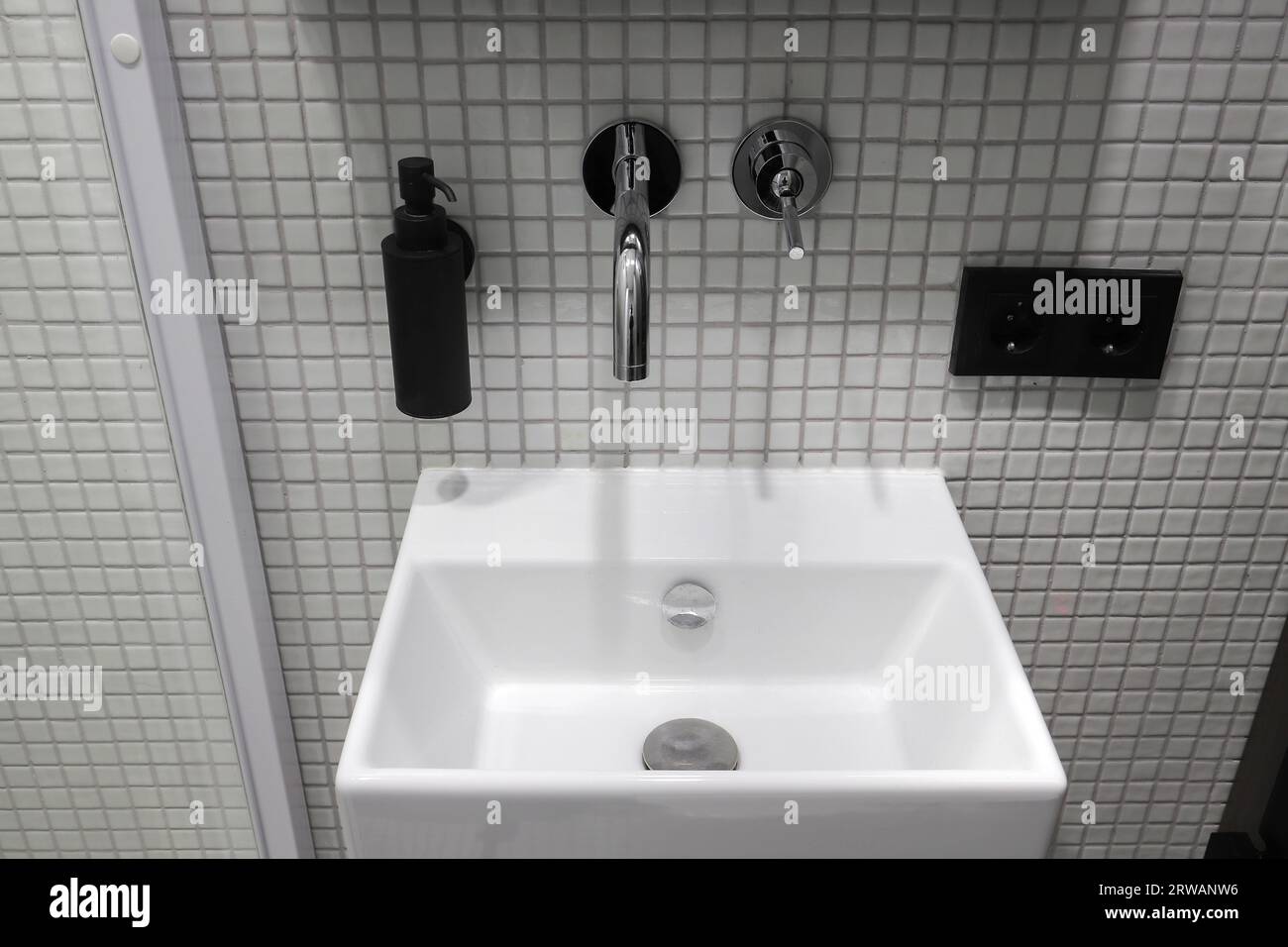 Rubinetto con lavandino in ceramica bianca all'interno del bagno Foto Stock Rubinetto con lavandino in ceramica bianca all'interno del bagno Foto Stock