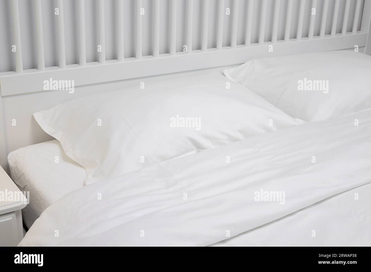 Cuscini bianchi vicini al letto Foto Stock