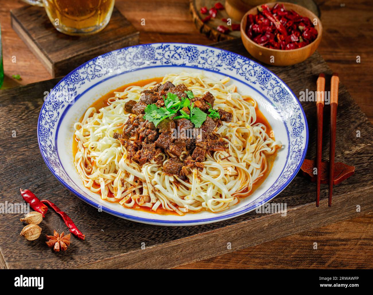 Spicy rosso zuppa di manzo spaghetti in una ciotola su tavolo di legno Foto Stock