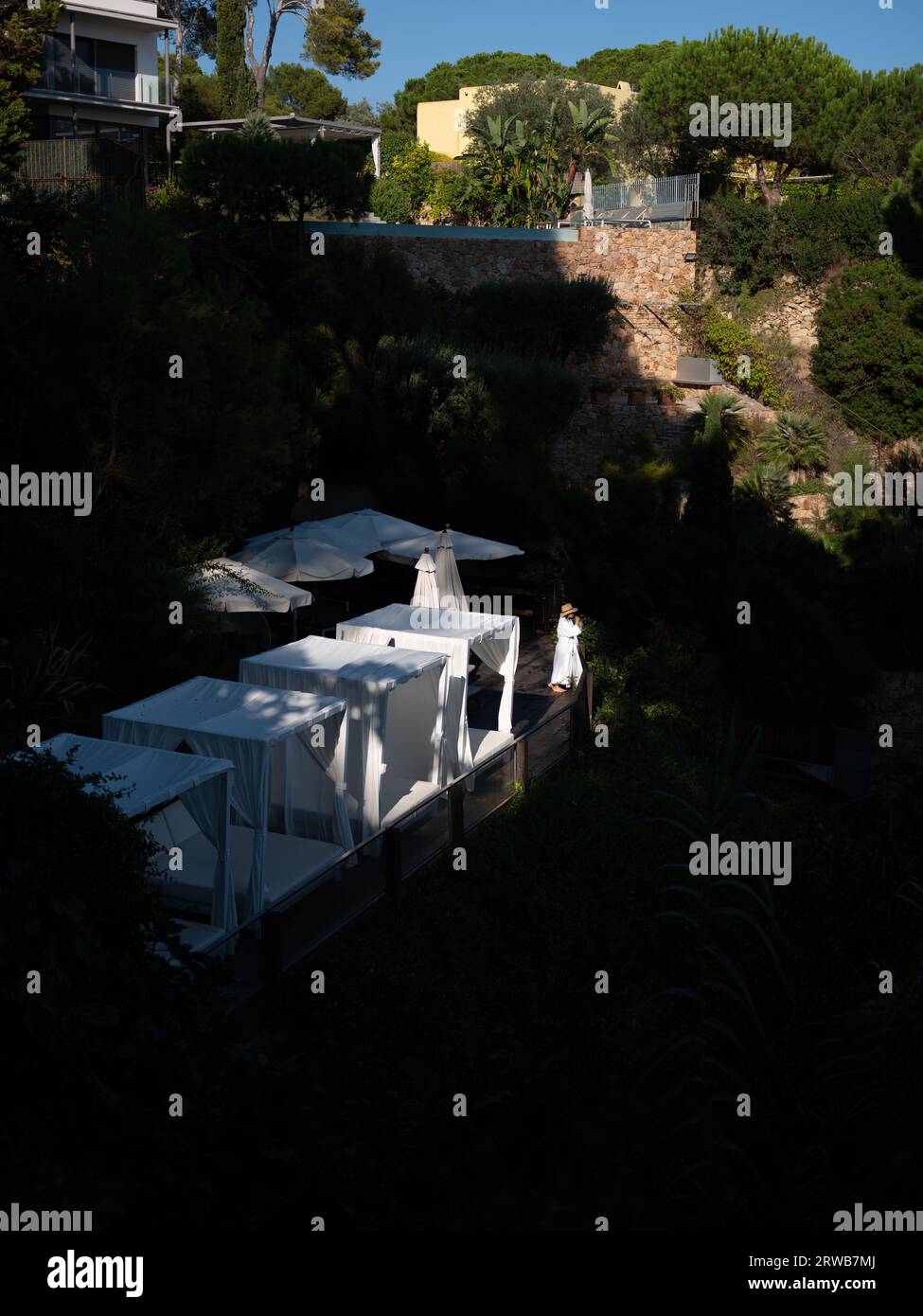 Una signora in accappatoio su un blacony di hotel che si affaccia sulla splendida costa di Platja d'Aro, in Catalogna, Spagna. Foto Stock