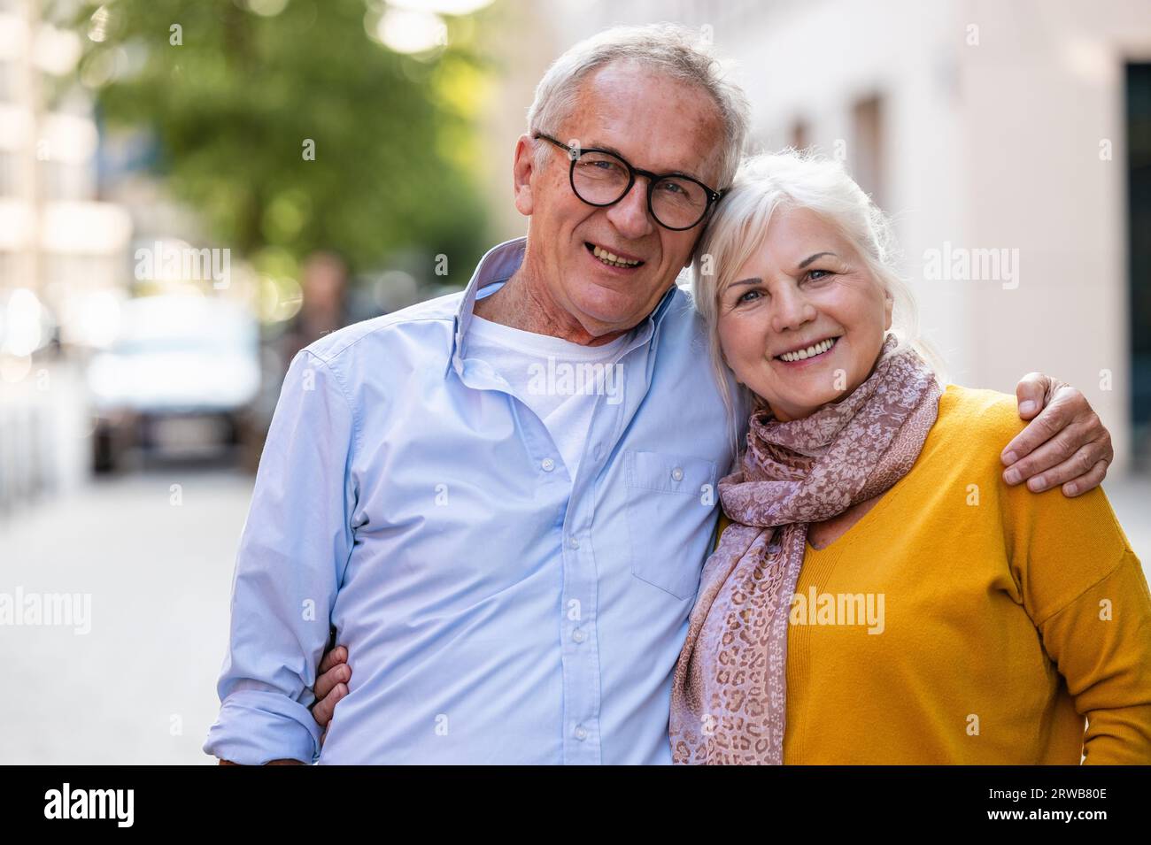 Ritratto di una felice coppia anziana che si abbraccia in città Foto Stock