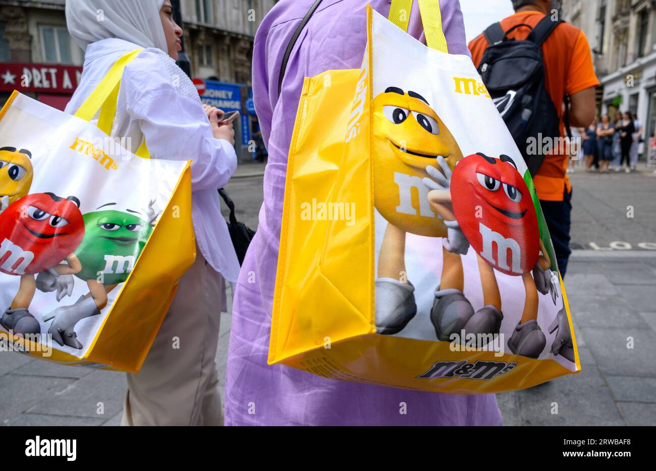 Londra, Regno Unito. Due donne musulmane con borse da trasporto M&MS Foto Stock