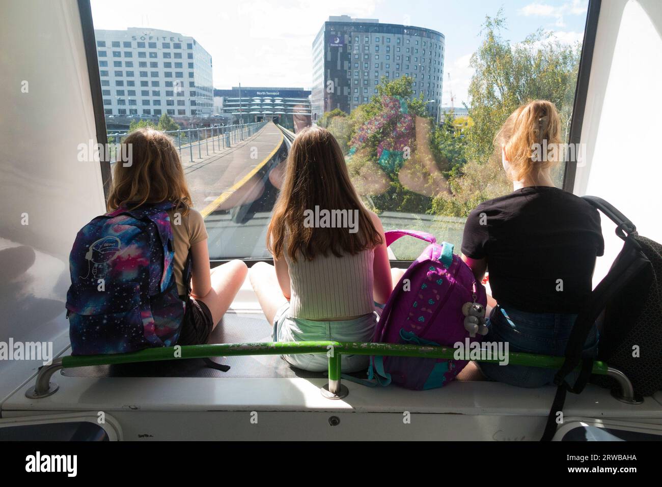 Tre sorelle, bambini, bambini, fanno un giro sul servizio navetta interterminale, il treno shuffle Gatwick tra il terminal nord e i terminal sud dell'aeroporto di Gatwick, Londra, Regno Unito. (135) Foto Stock