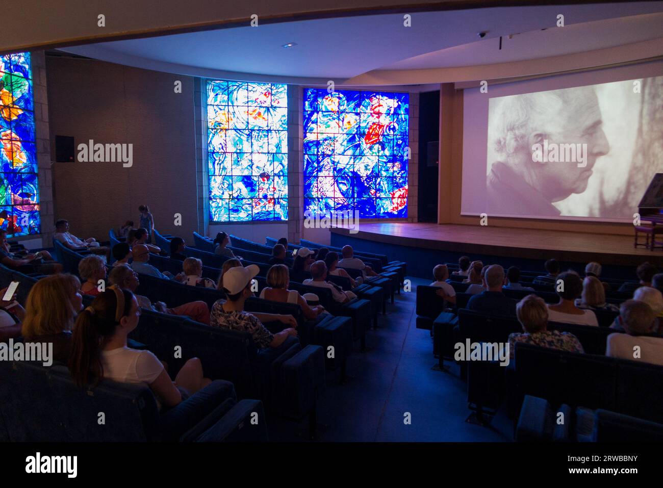 Il cortometraggio/video di Marc Chagall nel cinema per visitatori del Musée National Marc Chagall. Bello. Francia. I pannelli delle finestre in vetro colorato sono illuminati accanto allo schermo. (135) Foto Stock
