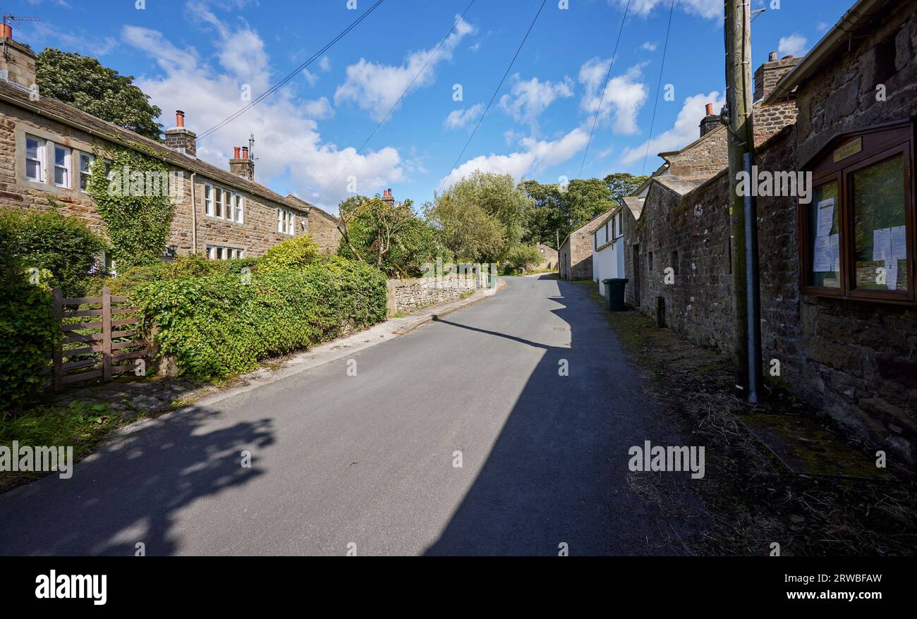 Una strada di campagna e tradizionali cottage Dales in una soleggiata giornata di agosto ad Halton East Foto Stock