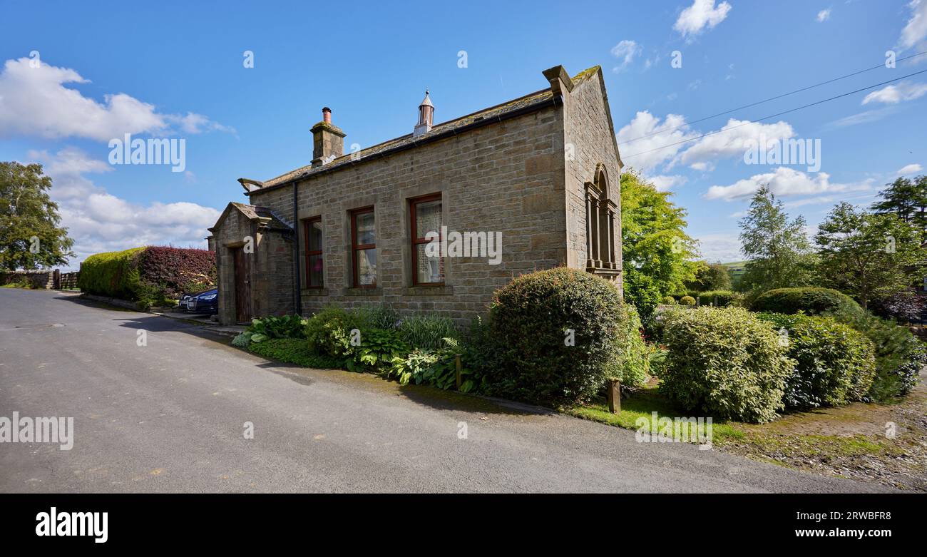 Una strada di campagna e tradizionali cottage Dales in una soleggiata giornata di agosto ad Halton East Foto Stock