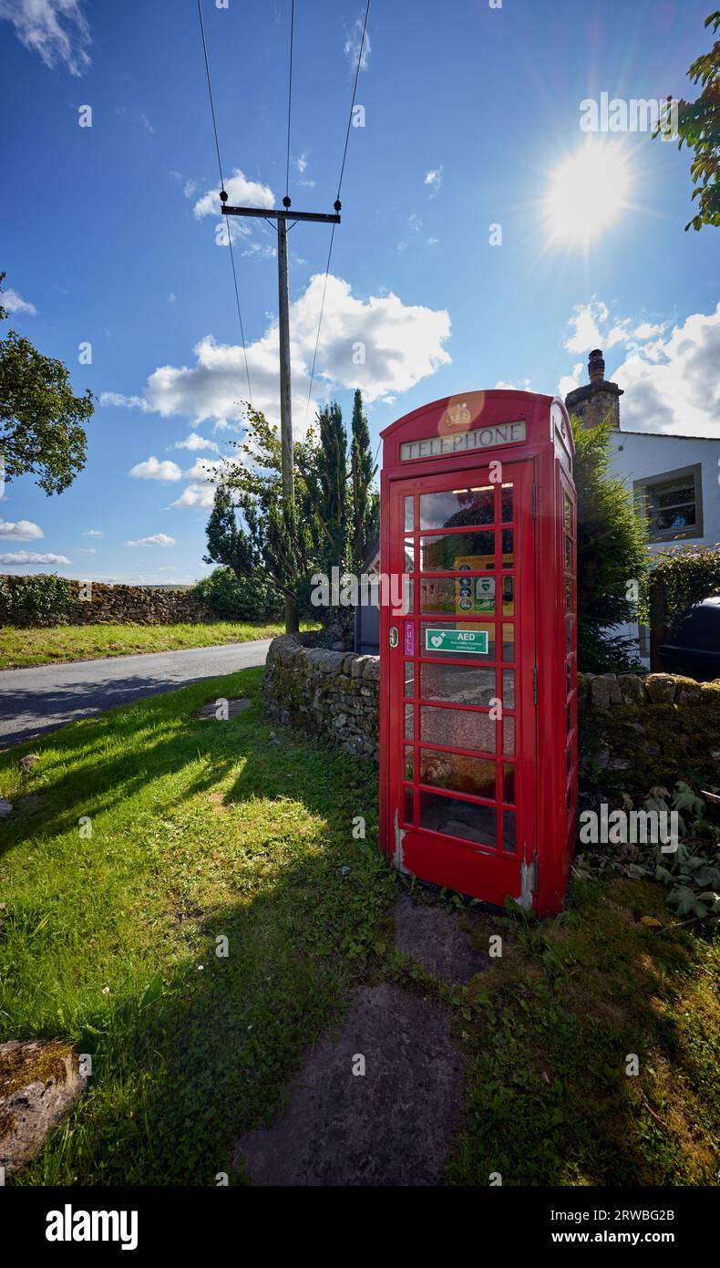 Nel centro del villaggio, un chiosco telefonico convertito in casa di un defibrillatore Foto Stock
