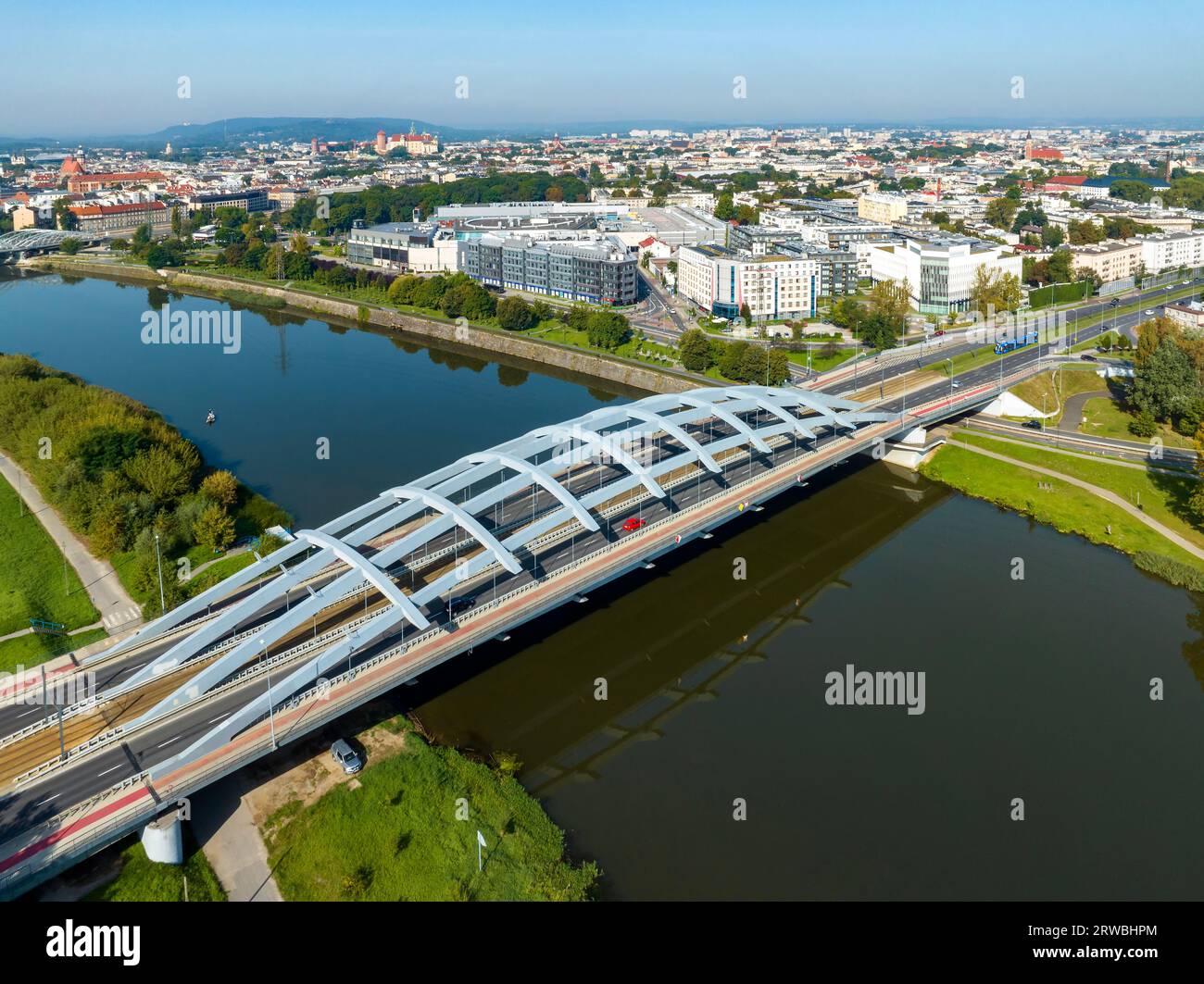 Cracovia, Polonia. Ponte sospeso Kotlarski con autostrada cittadina a quattro corsie, tram, piste ciclabili rosse e passaggi pedonali sul fiume Vistola. Città vecchia con Wawel Foto Stock