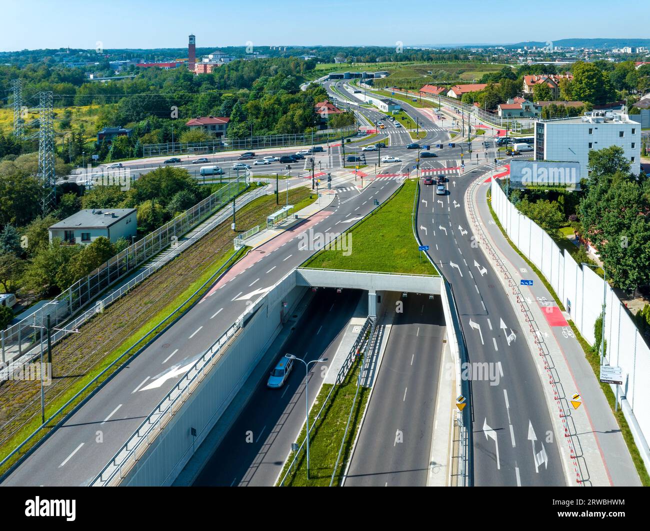 Autostrada cittadina di Cracovia, chiamata Trasa Lagiewnicka, con strade a più corsie con tunnel, incroci per auto e tram, piste ciclabili, passerelle con zebra cr Foto Stock