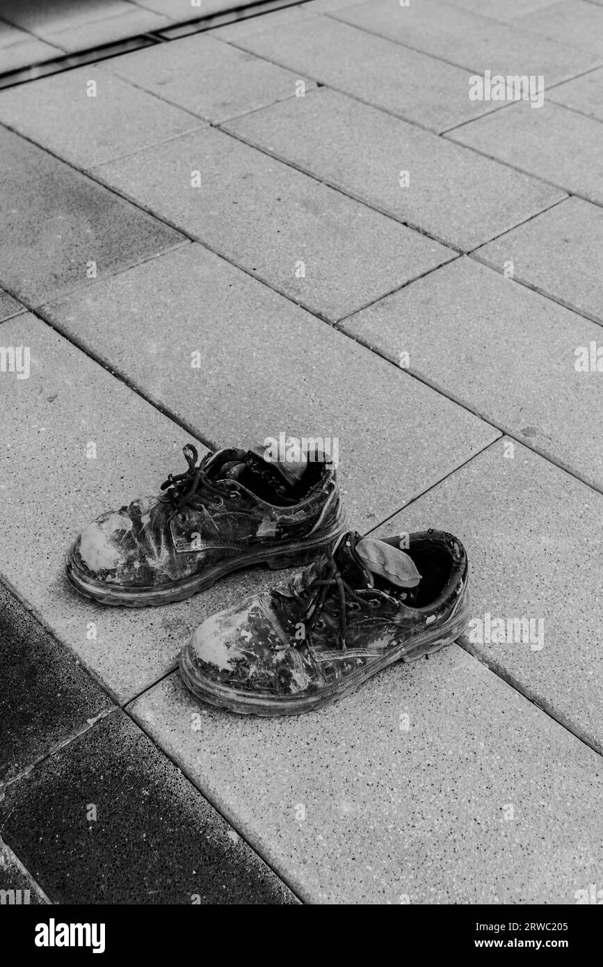 Scarpe da lavoro duro a Dubai operaio edile stradale riprese concettuali di scarpe. Cementevecchie scarpe trasandate stivali da lavoro vecchi. Foto di alta qualità Foto Stock