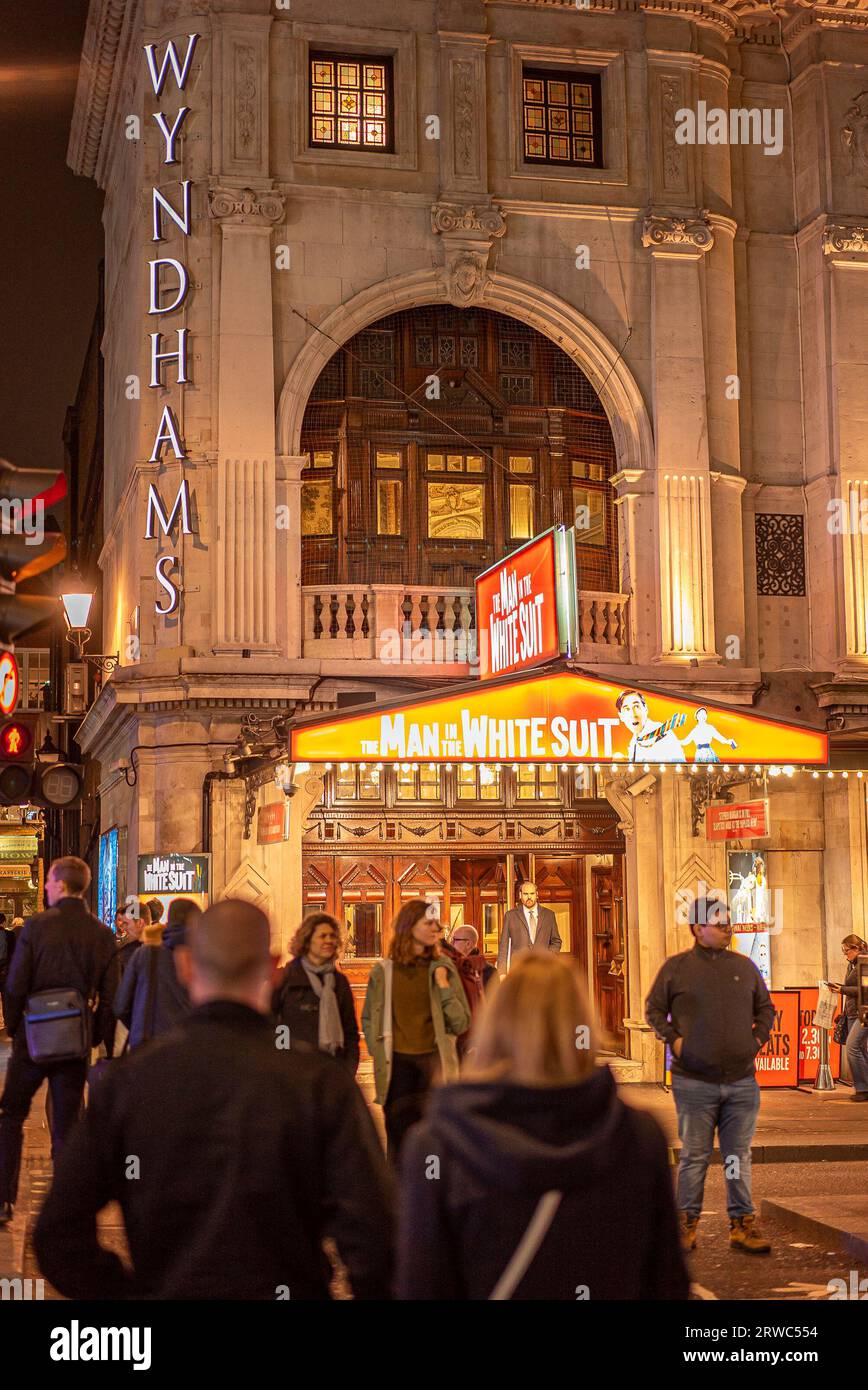 Wyndham's Theatre, West End, Londra, Regno Unito - ingresso anteriore dell'edificio illuminato di notte con persone fuori dalla strada. Foto Stock