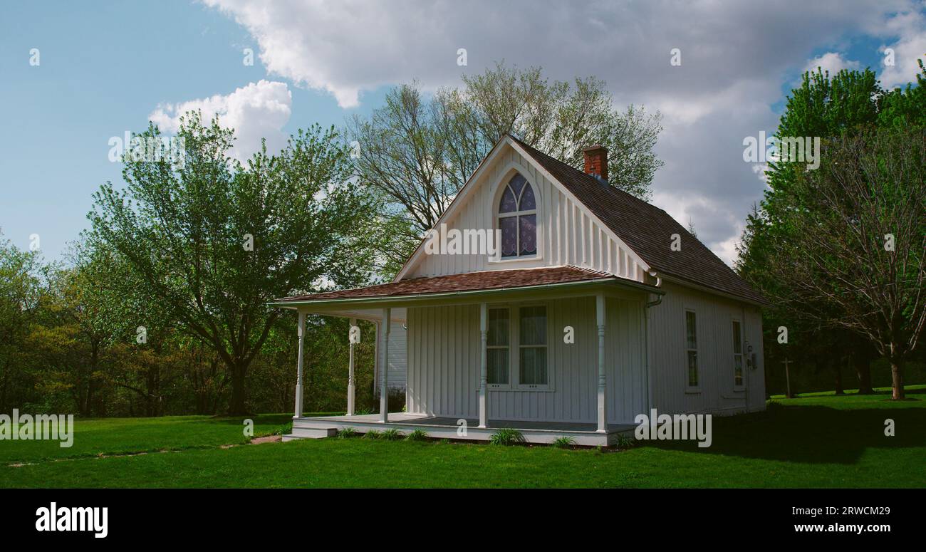 La casa gotica americana, famosa per il suo rapporto con l'iconico dipinto di Grant Wood, in una perfetta giornata primaverile in Iowa. Foto Stock