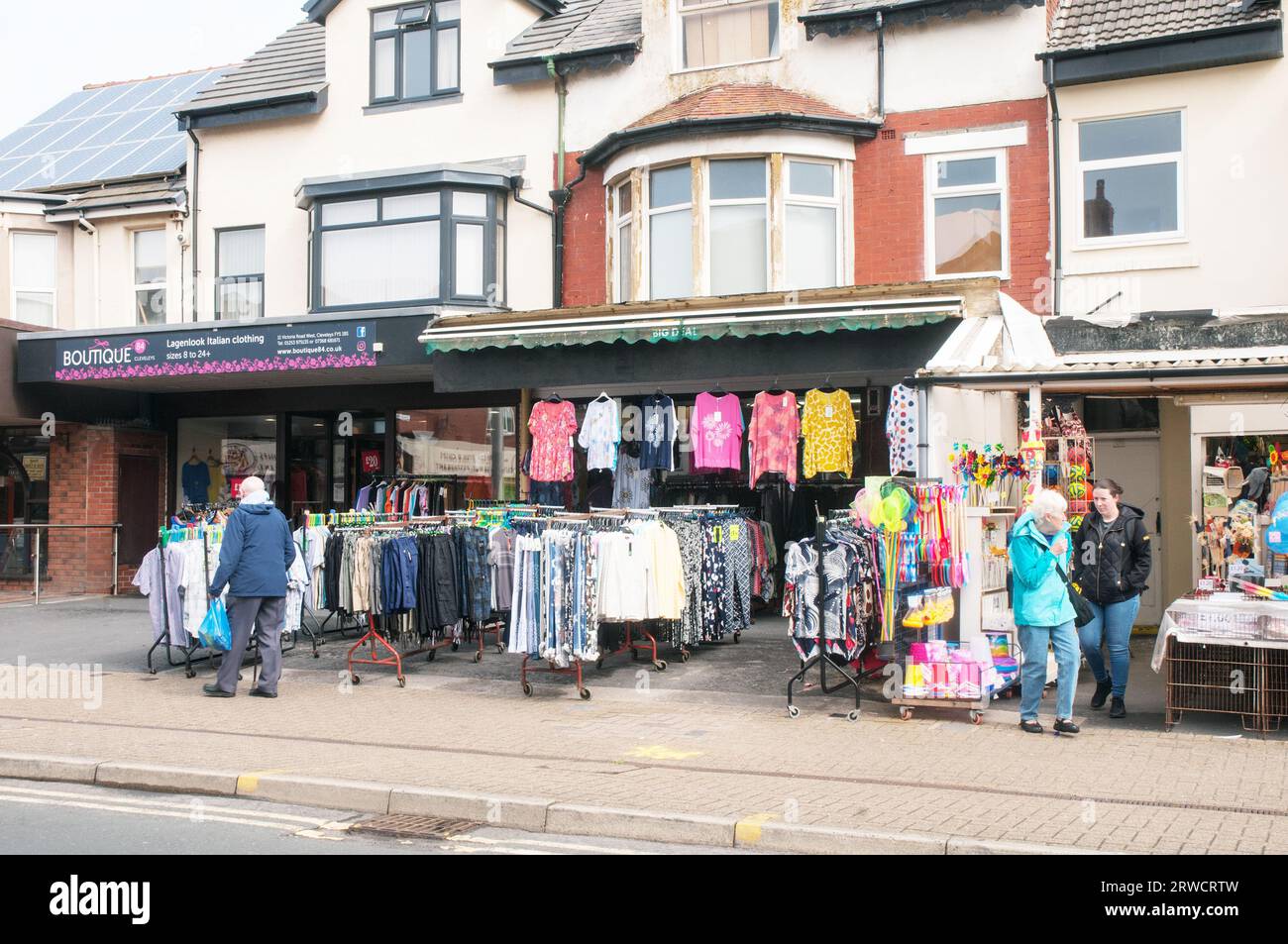 Camicie e altri capi di abbigliamento in vendita all'aperto nell'area pedonale all'esterno del negozio a Cleveleys Lancashire Inghilterra Regno Unito Foto Stock