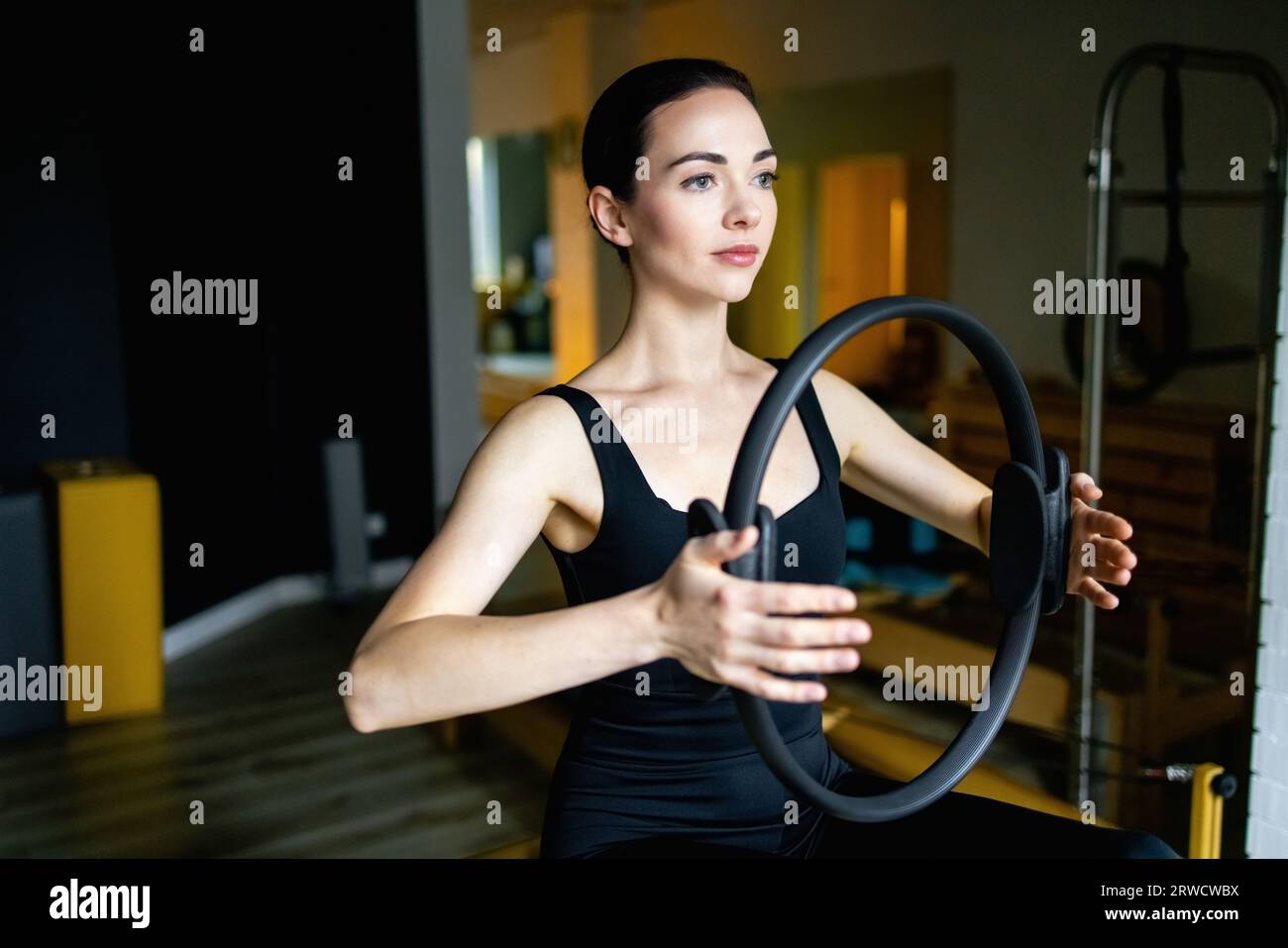 Donna sportiva che fa il pilates tonificando l'esercizio con l'anello. Foto Stock