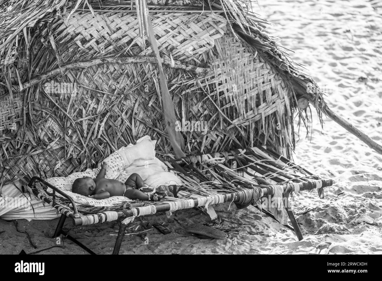 14 febbraio 2023, città di Chennai, India: Un bambino nomade è sdraiato su un letto all'interno di un rifugio temporaneo. Foto Stock