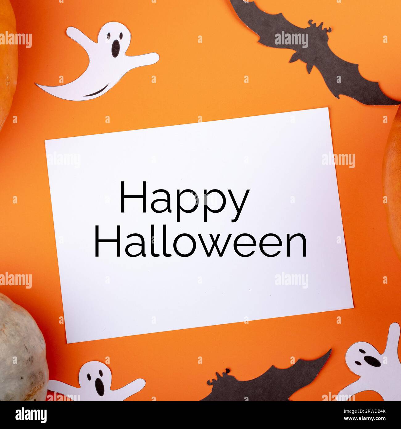 Testo di halloween felice su bianco con fantasmi e pipistrelli su sfondo arancione Foto Stock