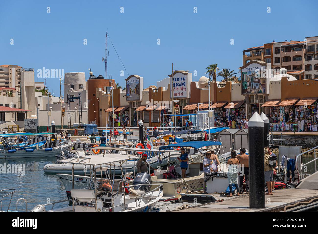 Messico, Cabo San Lucas - 16 luglio 2023: Marina Mercado si affaccia sul cielo blu dietro un porto molto trafficato con le sue navi da diporto. Persone intorno a Foto Stock