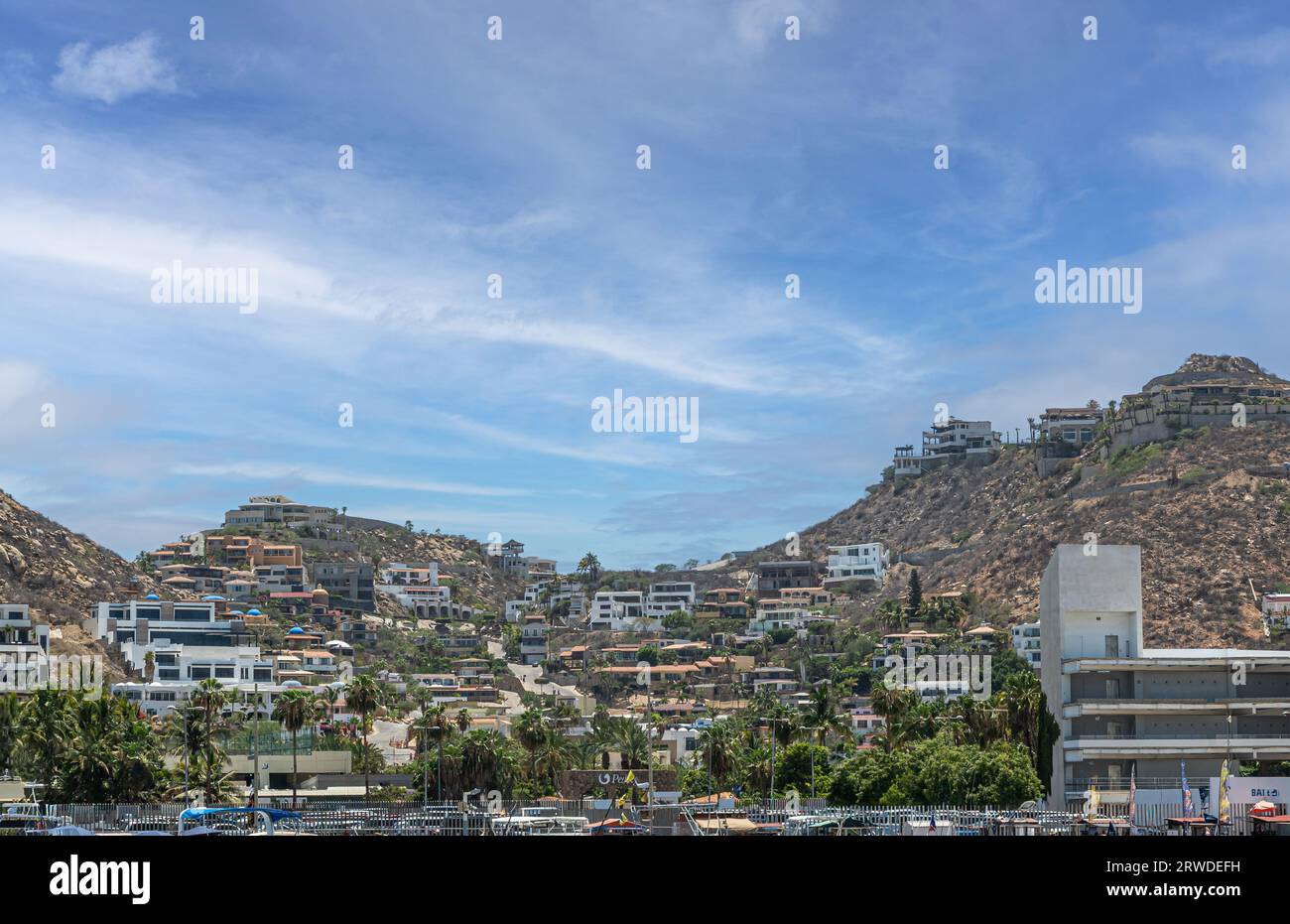 Messico, Cabo San Lucas - 16 luglio 2023: Architettura di lusso, alloggi residenziali e turistici su colline rocciose aride sopra il porto di Marina Mercado Foto Stock