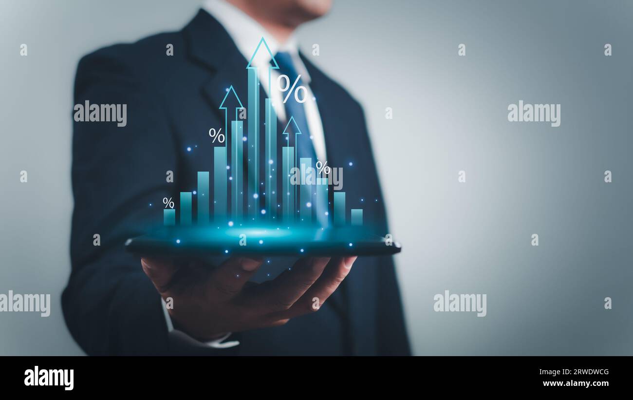 Un uomo d'affari ha in mano un tablet per visualizzare un grafico con i segni percentuali del futuro piano di crescita della sua organizzazione. Finanza, gestione, piano, ma Foto Stock