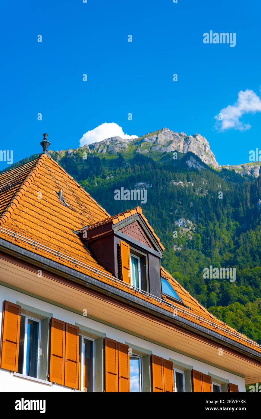 Casa a Iseltwald e montagna sul Lago di Brienz in una giornata di sole a Interlaken, Oberland Bernese, Cantone di Berna, Svizzera Foto Stock